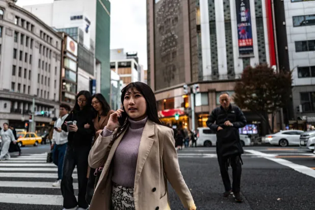 مشاة يعبرون الطريق في ضاحية غينزا التجارية بالعاصمة اليابانية طوكيو (أ.ف.ب)