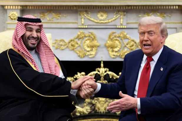 Prince Mohammed bin Salman, Saudi Crown Prince and Prime Minister laughs as US President Donald Trump speaks while shaking hands during a meeting in the Oval Office at the White House in Washington, DC, US, November 18, 2025. (Reuters) 