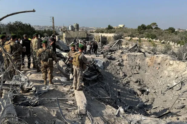 Lübnan askerleri, Güney Lübnan'daki Abbasiye kasabasında İsrail hava saldırısının hedef aldığı bir bölgede toplanıyor (Reuters)