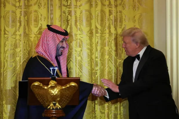 ABD Başkanı Donald Trump, Beyaz Saray'ın Doğu Salonu'nda düzenlenen akşam yemeğinde Suudi Arabistan Veliaht Prensi Muhammed bin Selman ile tokalaşıyor (AP)