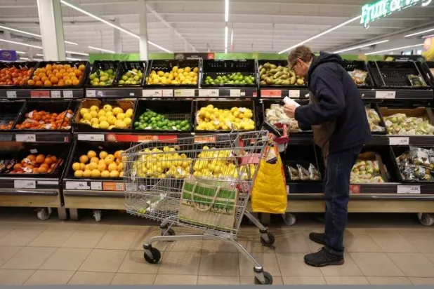 أحد الزبائن يتسوّق في قسم الفاكهة داخل أحد متاجر «سينسبري» بمنطقة ريتشموند غرب لندن (رويترز)