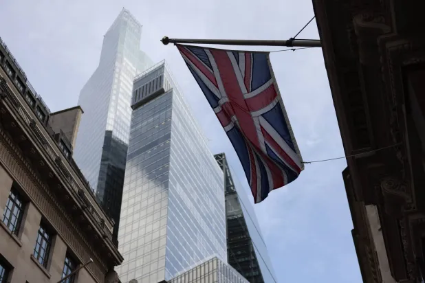يرفرف علم المملكة المتحدة بين المباني العالية والقديمة بمنطقة المال في «سيتي لندن» (إ.ب.أ)