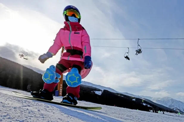 A snowboarder on a run at a ski field in Hami, Xinjiang, China, Feb. 3, 2022. (AFP)
