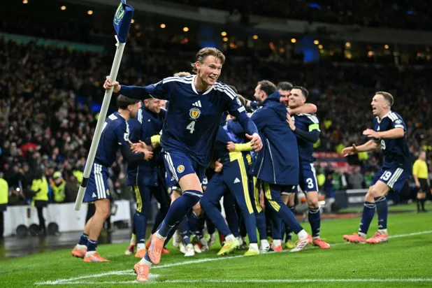 Scotland's midfielder #04 Scott McTominay grabs the corner flag as Scotland's midfielder #23 Kenny McLean celebrates with teammates after scoring his long-range last-kick of the game goal during the FIFA World Cup 2026 European qualification football match between Scotland and Denmark at Hampden Park in Glasgow on November 18, 2025. (AFP)