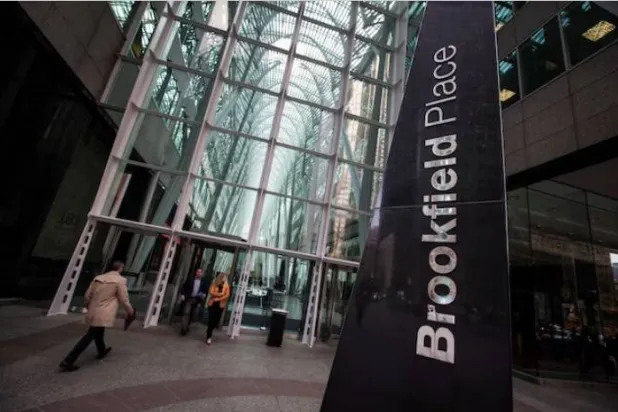 أشخاص يمشون نحو مبنى «بروكفيلد بليس» بشارع باي في تورونتو (أرشيفية - رويترز)