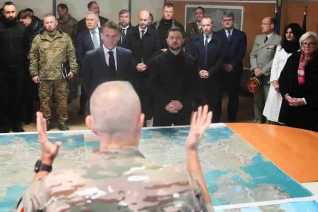 الرئيسان ماكرون وزيلينسكي يستمعان خلال زيارتهما الاثنين لمقر قيادة القوة متعددة الجنسيات من أجل أوكرانيا لشروح من أحد كبار الضباط (رويترز)