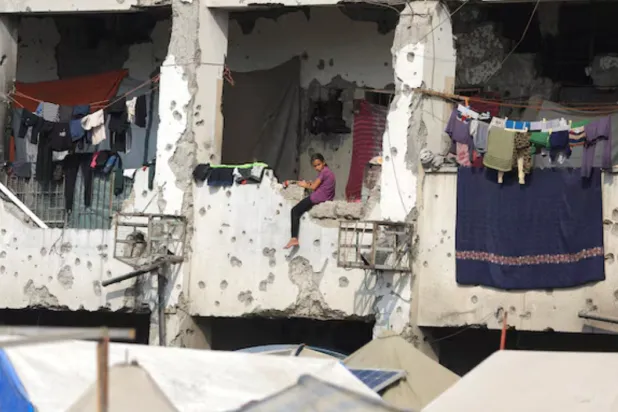 A displaced Palestinian girl sits on a wall of a damaged school where she has taken shelter in Gaza City, November 11. REUTERS/Dawoud Abu Alkas 