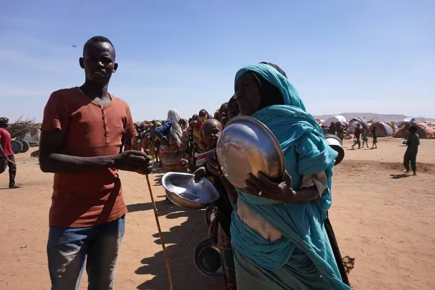 A handout picture released by the International Committee of the Red Cross (ICRC) on November 18, 2025 shows displaced civilians who have fled violence in el-Fasher gathering by makeshift camps in the city of Tawila. (Mohamed Jamal / ICRC / AFP) 