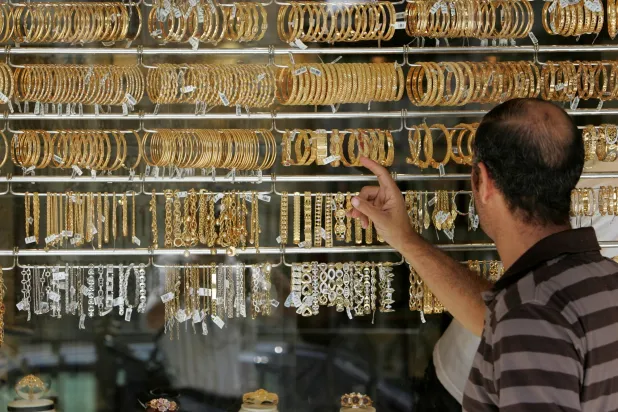 رجل أردني ينظر إلى أساور ذهبية معروضة في أحد المحال في سوق الذهب في عمان (رويترز)