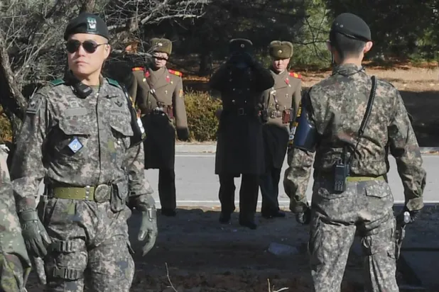 Korea Pool / AFP (file photo) | This file photo taken on November 27, 2017 shows North Korean soldiers staring at South Korean soldiers at the truce village of Panmunjom in the Demilitarized zone (DMZ).
