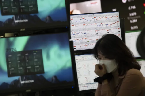 متداولة أمام شاشات تعرض مؤشرات الأسهم في بنك هانا بسيول (إ.ب.أ)