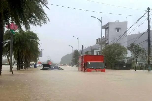19 November 2025, Vietnam, Quy Nhon: A truck drives through a flooded street in Quy Nhon after heavy rain and landslides caused flooding in Vietnam. Photo: Tran Van Thong/dpa