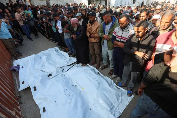 فلسطينيون يؤدون صلاتهم خلال حضورهم جنازة الذين قُتلوا إثر غارات إسرائيلية ليلية في مستشفى ناصر بخان يونس جنوب قطاع غزة (رويترز)