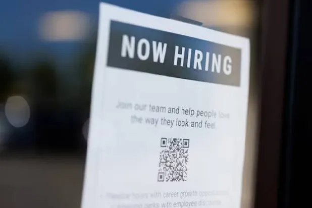 لافتة «نبحث عن موظفين» معلَّقة على أحد المتاجر المحلية بمدينة إنسينيتاس بولاية كاليفورنيا (رويترز)