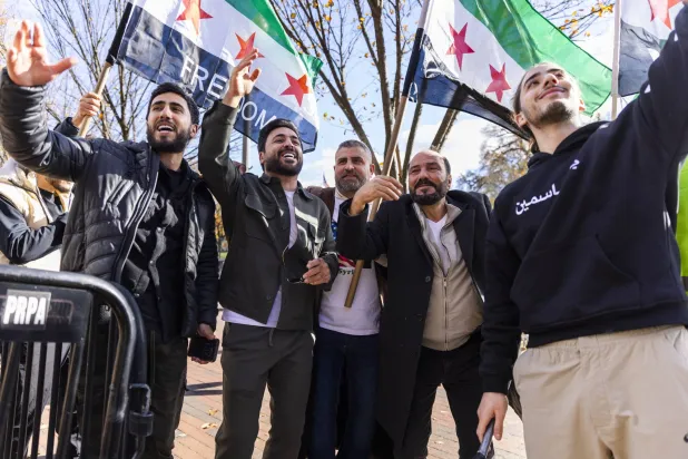 أنصار الرئيس السوري خارج البيت الأبيض بعد لقاء نظيره الأميركي ترمب في واشنطن يوم 10 نوفمبر (إ.ب.أ)