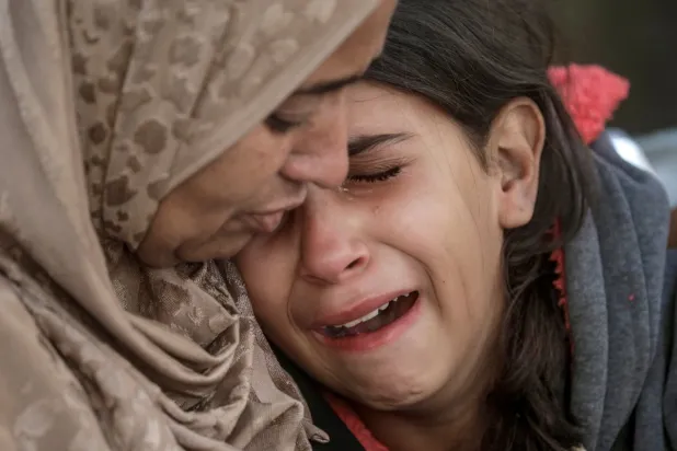 فلسطينيتان تنعيان مقتل أقارب لهما جراء غارة جوية إسرائيلية على مستشفى الشتاء في مدينة أمس (إ.ب.أ)