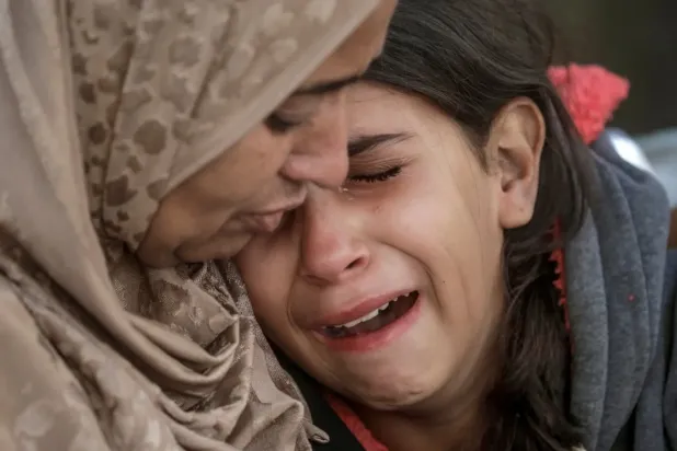 İki Filistinli kadın, İsrail'in Ams kentine düzenlediği hava saldırısında yakınlarını kaybetmelerinin acısını paylaşıyor (EPA).