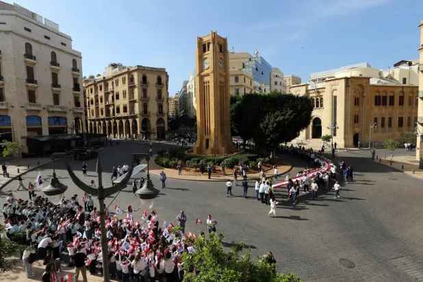School students carry a huge Lebanese flag on the occasion of Lebanon's 82nd Independence Day anniversary to be celebrated on 22 November, outside the Parliament building in downtown Beirut, Lebanon, 20 November 2025. EPA/WAEL HAMZEH