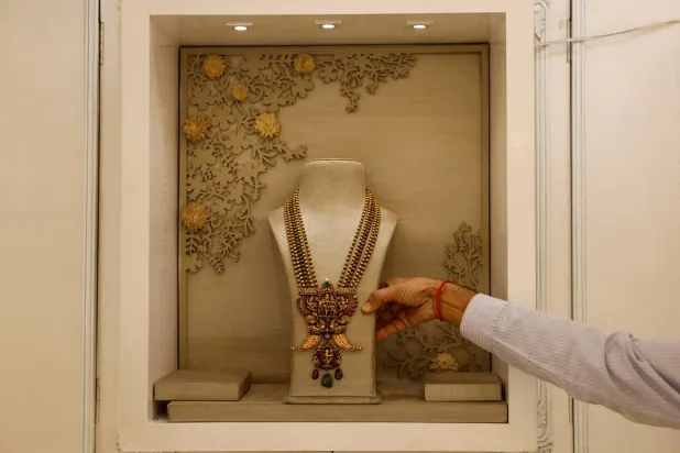 FILE PHOTO: A salesman shows a gold necklace on display inside a jewelry showroom in Kolkata, India, October 18, 2024. REUTERS/Sahiba Chawdhary/File Photo