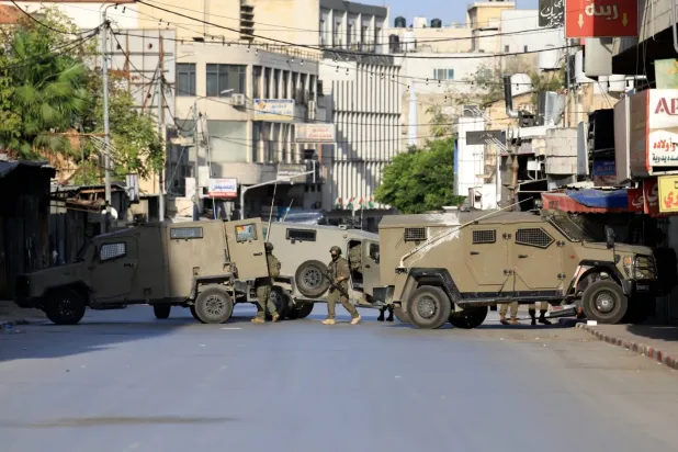 İsrail güçleri, 20 Kasım 2025'te Batı Şeria'nın Nablus kentinde bir askeri operasyon sırasında mevzi alıyor (EPA)