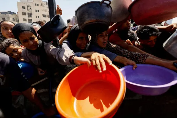 Palestinians wait to receive food from a charity kitchen in Gaza City, August 28, 2025. REUTERS/Mahmoud Issa/File Photo