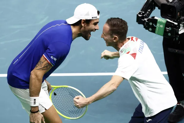 الإيطالي ماتيو بيريتيني يحتفل مع قائد إيطاليا فليبو فولاندري بالفوز في ديفيز (رويترز)