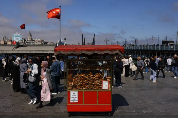 سياح وأتراك يتجولون أمام البوسفور في إسطنبول (رويترز)