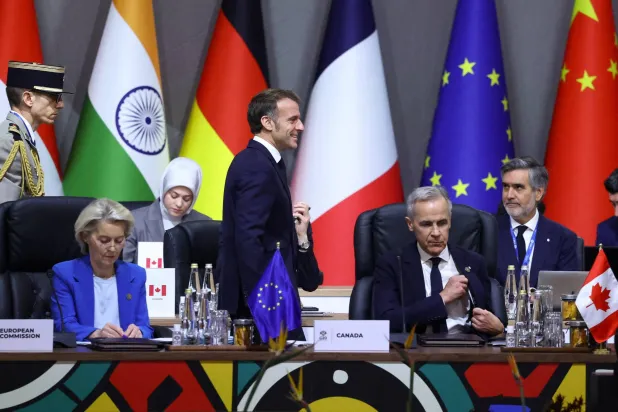 الرئيس الفرنسي إيمانويل ماكرون يمشي بجوار رئيسة المفوضية الأوروبية أورسولا فون دير لاين ورئيس الوزراء الكندي مارك كارني خلال جلسة عامة في قمة مجموعة العشرين بجوهانسبرغ (رويترز)