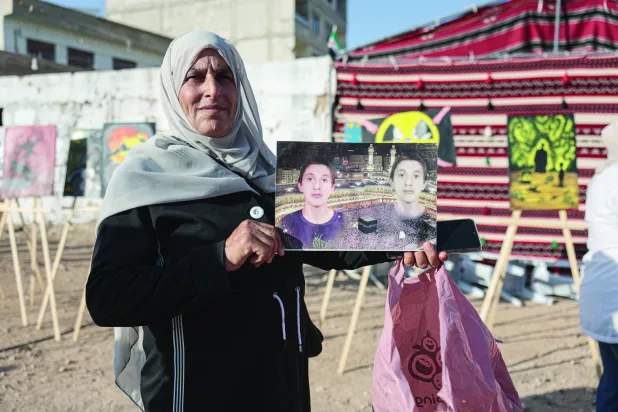 سوريّة تحمل صورة طفل قُتل في هجوم الغوطة الكيماوي عام 2013 خلال احتفال لإحياء ذكرى الهجوم في 21 أغسطس 2025 (إ.ب.أ)