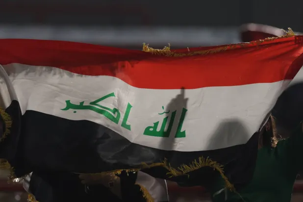 A fan holds an Iraqi flag during the FIFA World Cup 2026 Asian qualifiers play-off 1st leg soccer match between UAE and Iraq in Abu Dhabi, United Arab Emirates, 13 November 2025.  (EPA)