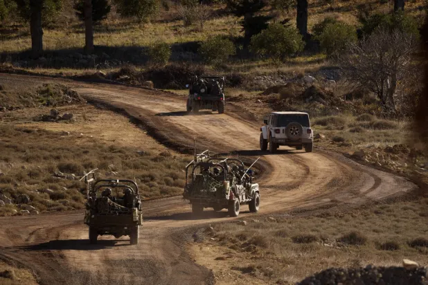 مدرعات إسرائيلية تقوم بمناورة في المنطقة العازلة بعد عبور السياج الأمني قرب الخط الفاصل بين مرتفعات الجولان المحتلة وسوريا في ديسمبر الماضي (أ.ب)