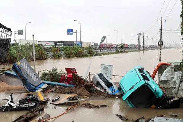 Vehicles are damaged due to floods at a charging station in Dak Lak, Vietnam Saturday, Nov. 22, 2025. (Do Van Truong/VNA via AP)