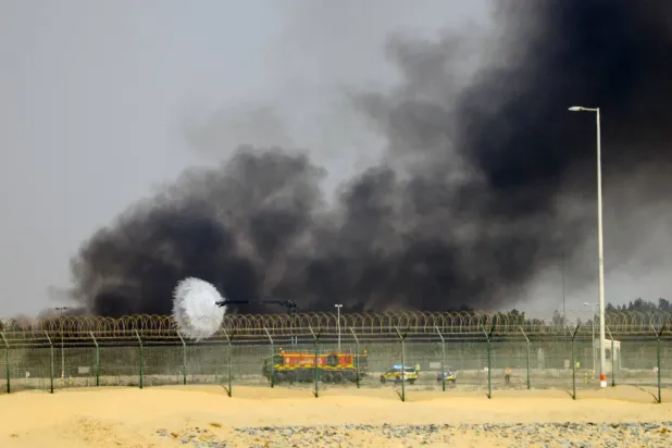 فرق الطوارئ في موقع تحطم الطائرة خلال «معرض دبي الجوي»... (إ.ب.أ)