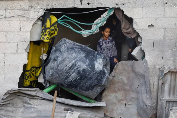 طفلة فلسطينية تتفقد موقع قصفه الجيش الإسرائيلي السبت في وسط غزة (رويترز)