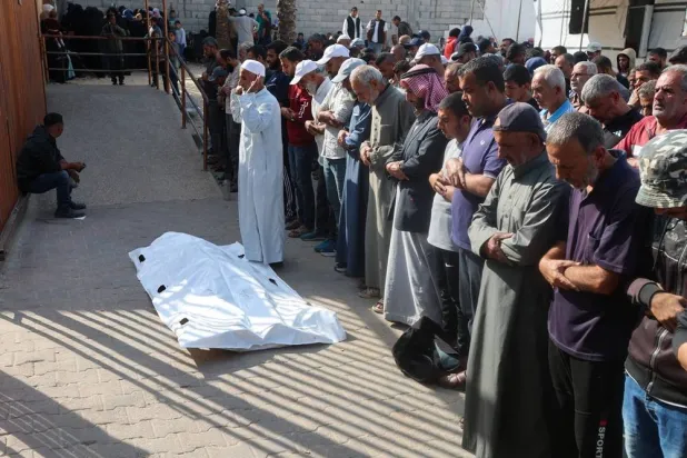 Mourners pray next to the body of one of two Palestinians killed by Israeli fire, according to medics, during their funeral at Nasser hospital in Khan Younis in the southern Gaza Strip, November 24, 2025. (Reuters)