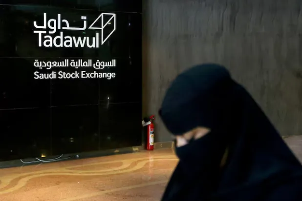 امرأة سعودية تسير في سوق الأسهم السعودية (تداول) بالرياض (رويترز)