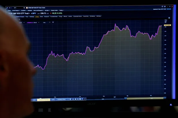 متداول ينظر إلى شاشة تعرض مخططاً لمؤشر «ستاندرد آند بورز 500» في بورصة نيويورك (رويترز)