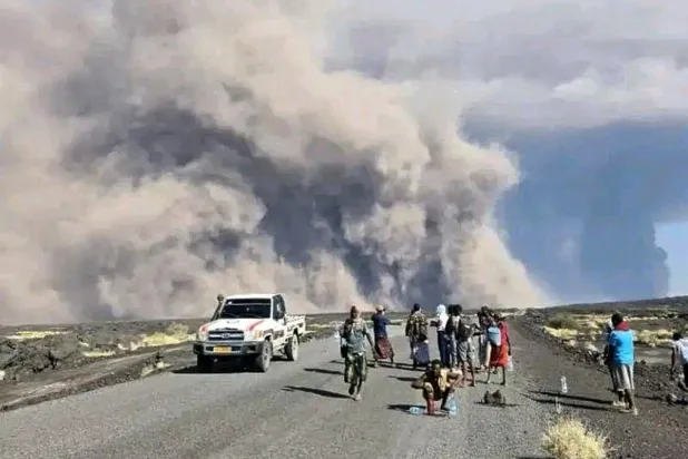 صورة وزعها المكتب الإعلامي لحكومة إقليم عفر لأشخاص يراقبون ثوران البركان هايلي غوبي في شمال شرقي إثيوبيا (أ.ب)