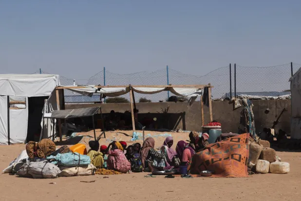 لاجئون سودانيون وصلوا حديثاً من الفاشر هرباً من الاشتباكات المستمرة بين «قوات الدعم السريع» والجيش السوداني يجلسون على الأرض داخل مخيم في شرق دولة تشاد... 23 نوفمبر 2025 (رويترز)