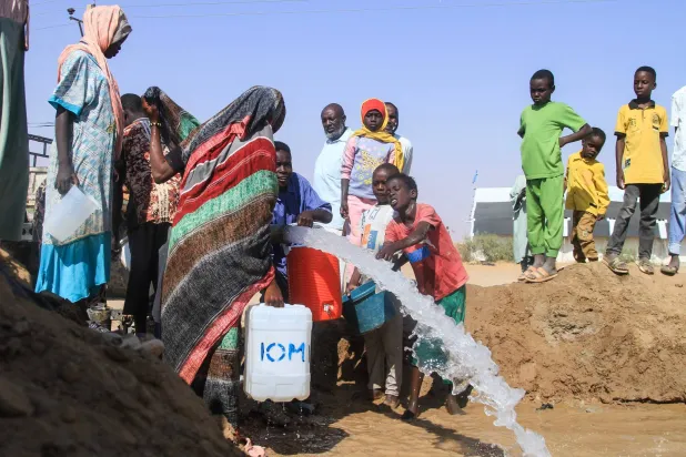 Sudanese who fled El-Fasher in Darfur fill jerrycans with water at the Al-Afad camp for displaced people in the town of Al-Dabbah, northern Sudan, on November 21, 2025. (Photo by Ebrahim Hamid / AFP)