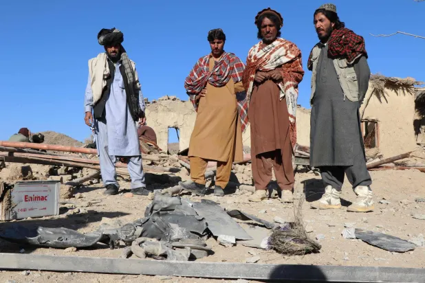 يقف السكان بالقرب من بقايا قذيفة هاون في منزل متضرر بعد غارة جوية باكستانية في جيغي موغالغاي بإقليم خوست - 25 نوفمبر 2025 (أ.ف.ب)