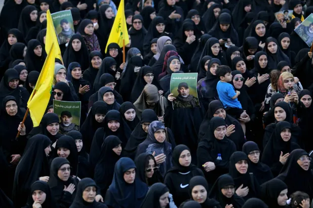 Mourners carry pictures of Haitham Tabtabai, who was killed in an Israeli strike a day earlier, during his funeral in Beirut's southern suburbs on November 24, 2025. (Photo by Ibrahim AMRO / AFP)