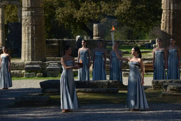 Greek actress Mary Mina (C-R), playing the role of High Priestess, holds the flame during the rehearsal of the Olympic flame lighting ceremony for the Milano Cortina 2026 Winter Olympics at the Ancient Olympia site in southern Greece, 24 November 2025. EPA/DIMITRIS PAPAIOANNOU