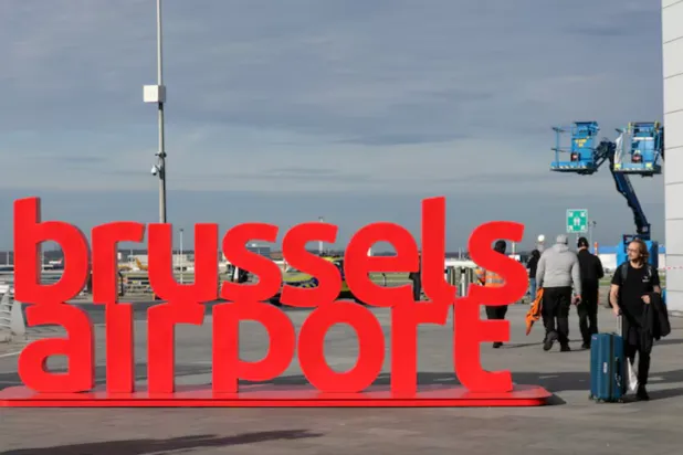 People walk past a sign at Brussels Airport, in Zaventem, Belgium, November 5, 2025. REUTERS/Yves Herman 