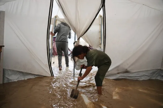  Saja Fayyad, 7, tries to clear water from her family's flooded tent at a temporary camp for displaced Palestinians after heavy rainfall in Deir al-Balah, central Gaza Strip, Tuesday, Nov. 25, 2025. (AP) 