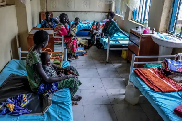 Güney Sudan'ın Bor kentindeki bir hastanenin yetersiz beslenme tedavi koğuşunda çocuklarıyla birlikte oturan anneler, (Arşiv- AP)