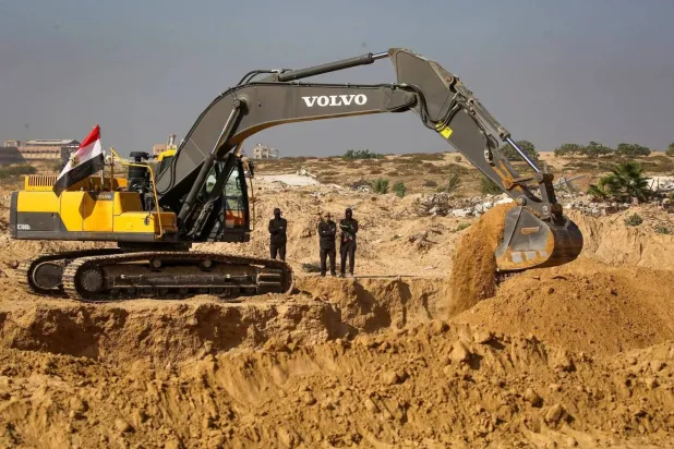Masked Palestinian Islamic Jihad gunmen search for bodies in Nuseirat in central Gaza (AFP)