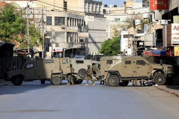 Israeli troops take positions during an Israeli military operation in the West Bank city of Nablus, 20 November 2025. (EPA)