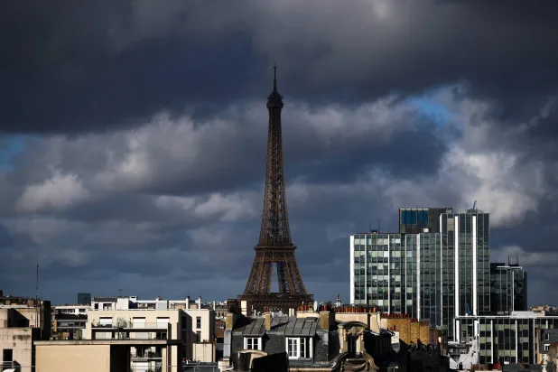 The Eiffel Tower, city rooftops and chimney stacks are seen on a cloudy day in Paris, France, November 24, 2025. (Reuters)