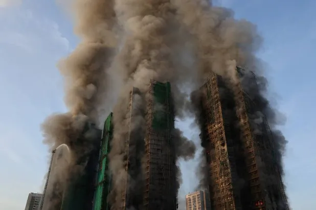 Smoke rises as flames engulf bamboo scaffolding across multiple buildings at Wang Fuk Court housing estate, in Tai Po, Hong Kong, China, November 26, 2025. (Reuters) 